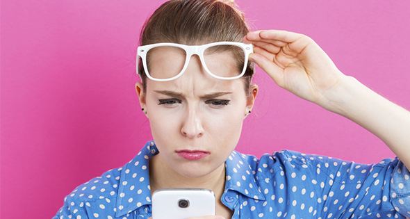 Femme en train de regarder son portable avec suspicion (Istock)