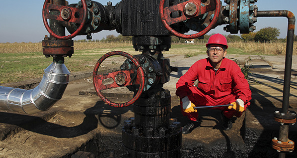 Technicien devant une canalisation de puits de pétrole (Istock)