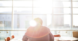 homme installé à un bureau face à une fenêtre