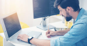 homme qui travaille avec plusieurs ordinateurs