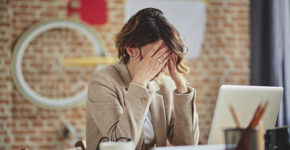 Femme en dépression les mains dans les cheveux au bureau (Istock)