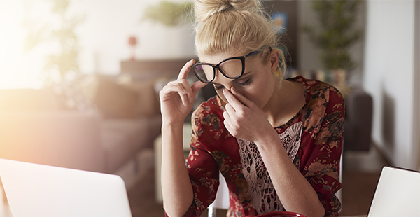 Femme à son bureau en train de souffler un moment (Istock)