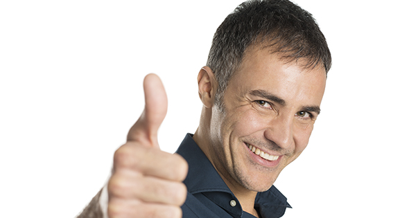 Homme au grand sourire avec le pouce pointé vers le haut (Istcok)